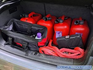 Wnętrz bagażnika samochodowego a w nim czerwone kanistry plastikowe