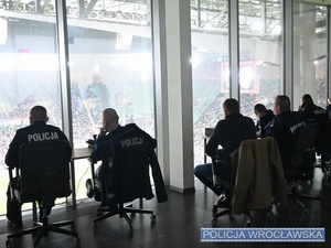 Dowódca zabezpieczenia Zastępca Komendanta Miejskiego Policji we Wrocławiu mł. insp. Sławomir Wołk oraz inni umundurowani policjanci w pomieszczeniu stadionu.
