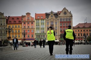 Zdjęcie przedstawia policjantów patrolujących wrocławski Rynek