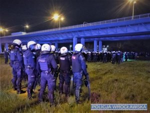 Zdjęcia przedstawiają policjantów zabezpieczających mecz