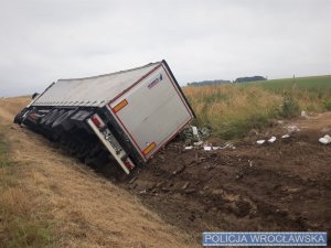 Przewrócona na bok ciężarówka na poboczu autostrady