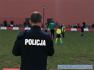 Policjant na tle grających piłkarzy