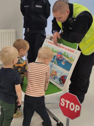 Policjant pokazujący dzieciom plansze edukacyjne