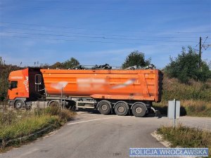 Zdjęcia niesprawnej, pomarańczowej ciężarówki na poboczu drogi