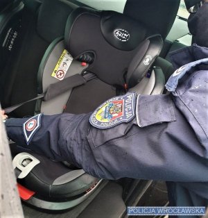 Policjant przy foteliku samochodowym