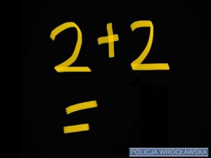 Na czarnym tle żółty napis z równaniem &quot;2 + 2 = &quot;