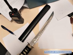Nóż wyjęty z pochwy leżące na biurku