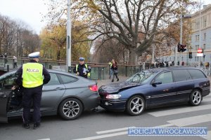Zdjęcia przedstawiają dwa uszkodzone pojazdy oraz umundurowanych policjantów