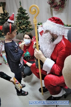 Święty Mikołaj wręczający chłopcu prezent