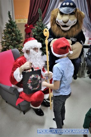 Święty Mikołaj oraz Komisarz Lew wręczający dzieciom prezenty