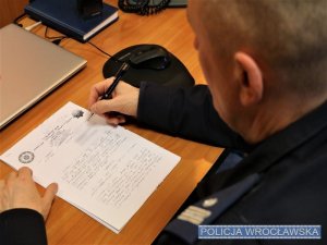 Umundurowany policjant siedzący przy biurku