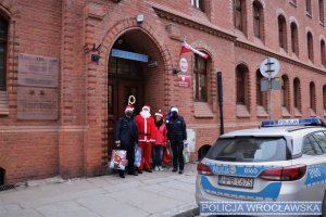 Policjanci oraz pracownicy MOPS przed wejściem do komisariatu