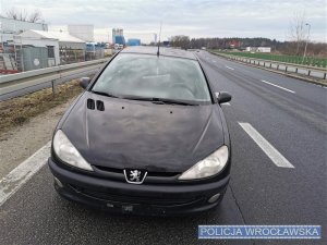 Czarny osobowy Peugeot widziany z przodu