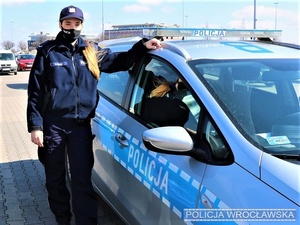 Policjantka stojąca przy radiowozie