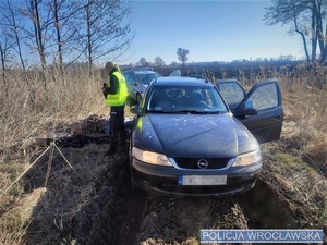 Kontrolowany Opel oraz 3 zatrzymane osoby z policjantami