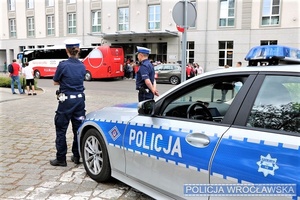 Policjanci z drogówki na tle autobusu reprezentacji Polski