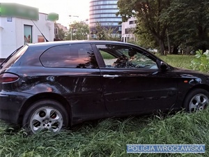 Stojące na trawniku przy bloku auto osobowe