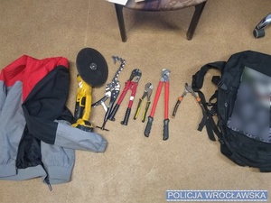 Od lewej bluza z kapturem, szlifierka, narzędzia oraz plecak