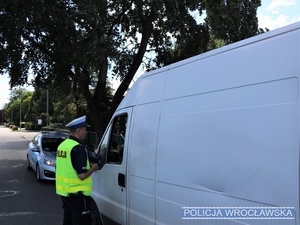 Policjant rozmawiający z kierowcą białego busa