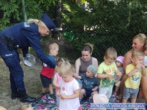 Policjantka wręczająca dzieciom odznaki