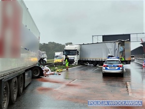 Miejsce zdarzenia drogowego i widoczny uszkodzony zespół pojazdów ciężarowych na autostradzie