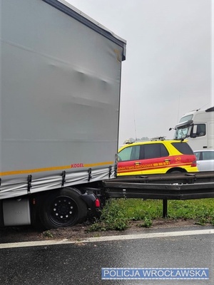 Miejsce zdarzenia drogowego i widoczny uszkodzony zespół pojazdów ciężarowych na autostradzie