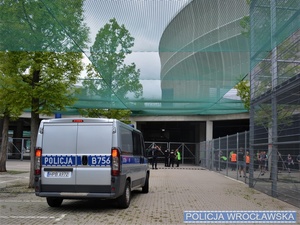 policyjny radiowóz na tle stadionu