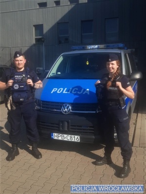 Policjanci stojący przy radiowozie