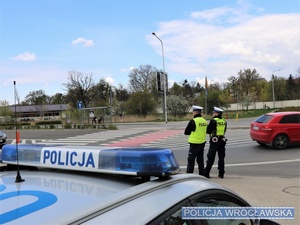 Stojący na oznakowanym przy przejściu dla pieszych dwaj umundurowani policjanci - zdjęcie ilustracyjne