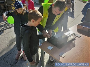 Policjant pokazujący pobieranie odcisków palców