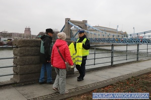 Policjantka rozdająca odblaskowe kamizelki