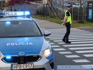 Policjant na przejściu dla pieszych kierujący ruchem