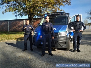 Policjanci z Oddziału Prewencji Policji we Wrocławiu stojący przy radiowozie