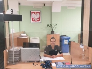 Policjantka w mundurze w okienku w palcówce ZUS dla obsługi interesnatów