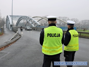 Dwaj umundurowani policjanci ruchu drogowego na jednej z wrocławskich ulic.