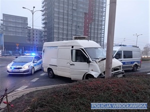 Stojące na jednej z wrocławskich ulic uszkodzony pojazd typu bus oraz dwa oznakowane radiowozy