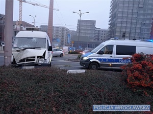 Stojące na jednej z wrocławskich ulic uszkodzony pojazd typu bus oraz oznakowany radiowóz