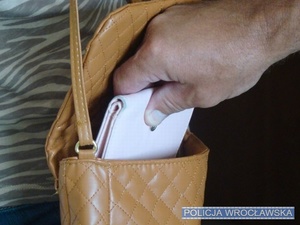 Zdjęcie ilustracyjne - ręka wyciągająca portfel z torebki