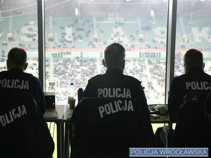 Policjanci w mundurach siedzący na trybunach stadionu zdjęcie wykonane od tyłu.