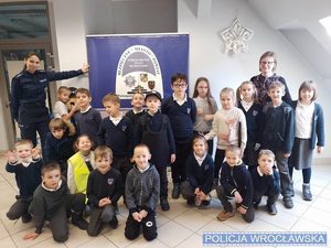Grupa dzieci w pomieszczenuiu policjantką w mundurze