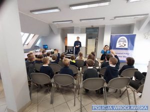 Policjantka w mundurze prowadzi zajęcia z grupą dzieci
