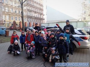 Grupa dzieci na tle policyjnego radiowozu