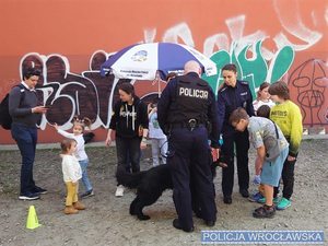 Grupa młodzieży wraz z policjantami w mundurze pies służbowy