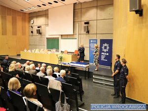 Aula uniwersytecka a w niej przemawia Naczelnik Wydziału Prewencji Komendy Miejskiej Policji we Wrocławiu