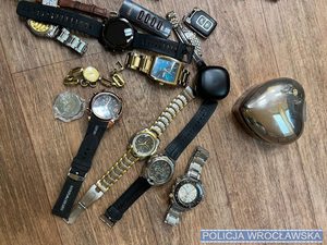 Zegarki, biżuteria leżące na blacie stołu
