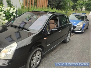 Zdjęcie zaparkowanych na jednej z wrocławskich ulic pojazdu osobowego oraz stojącego za nim oznakowanego radiowozu Policji