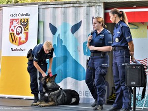 Policjantki w mundurach służbowych na scenie wraz z psem służbowym