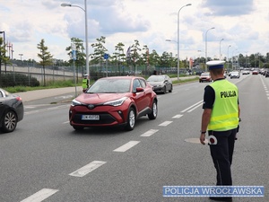 Policjanci kierujący ruchem na ulicy przed stadionem we Wrocławiu.