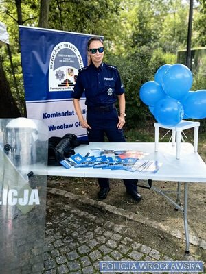 Policjantka w mundurze na stoisku promocyjnym Policji