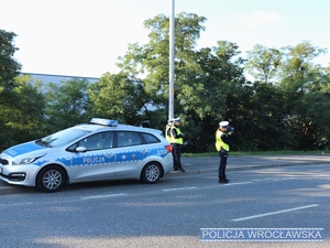 Funkcjonariuszki Wydziału Ruchu Drogowego wrocławskiej komendy miejskiej podczas kontroli drogowej i pomiaru prędkości na posterunku stałym, na jednej z wrocławskich ulic - zdjęcie ilustracyjne.